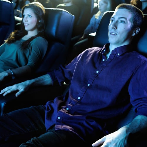 Moviegoer couple watching a movie in theater seats
