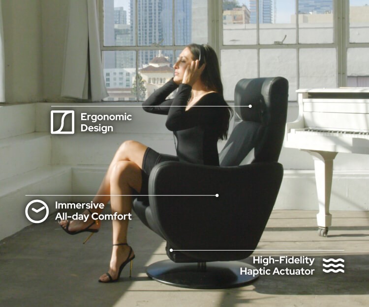 A woman sits on a home haptic chair listening to music
