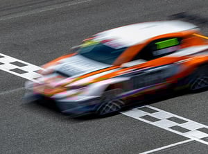 A blurry race car crossing the finish line in motion