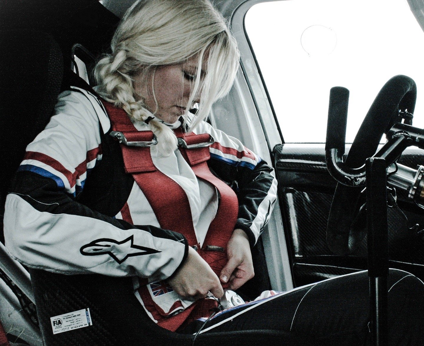 Louise Cook buckles herself into her rally car