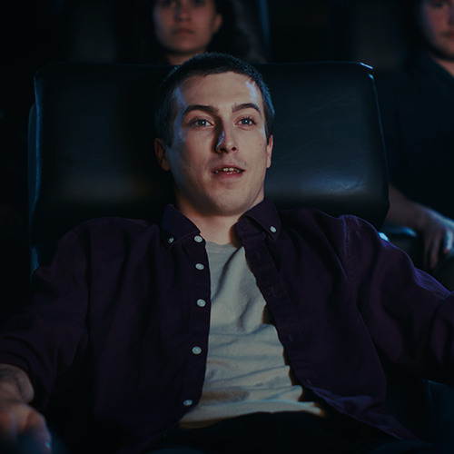 Un homme qui est assis dans une chaise de cinema