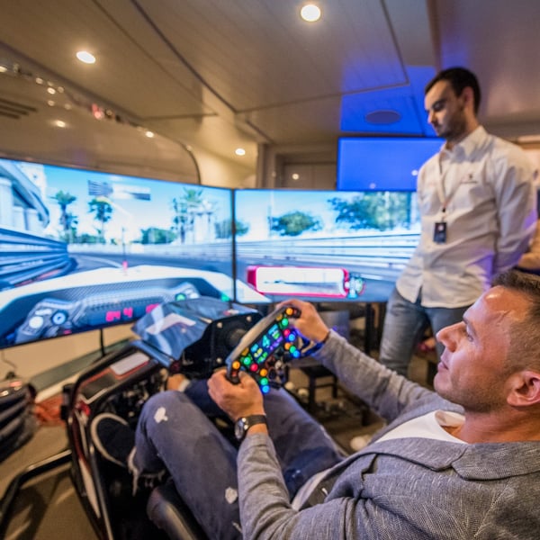 Men playing on a sim racing rig