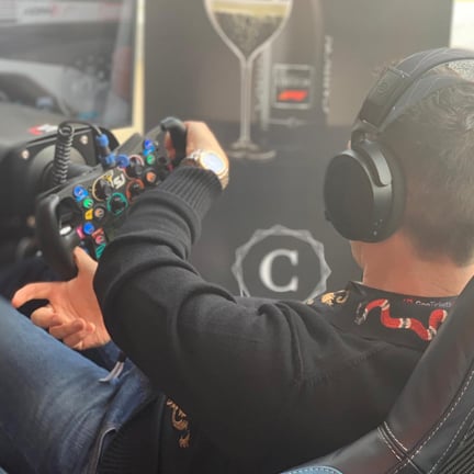 A man turning a sim racing steering wheel from his rig.