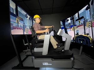 A man training on a heavy vehicle simulator