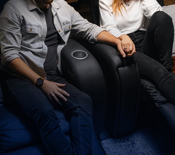 Un couple se tiennent la main alors qu'ils sont assis dans un siège haptique D-BOX