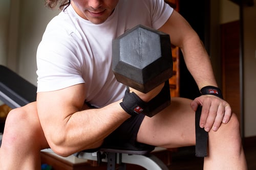 Man doing a muscular effort while lifting weights 