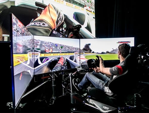 Sim Racer seating in a racing simulator with haptic feedback actuators
