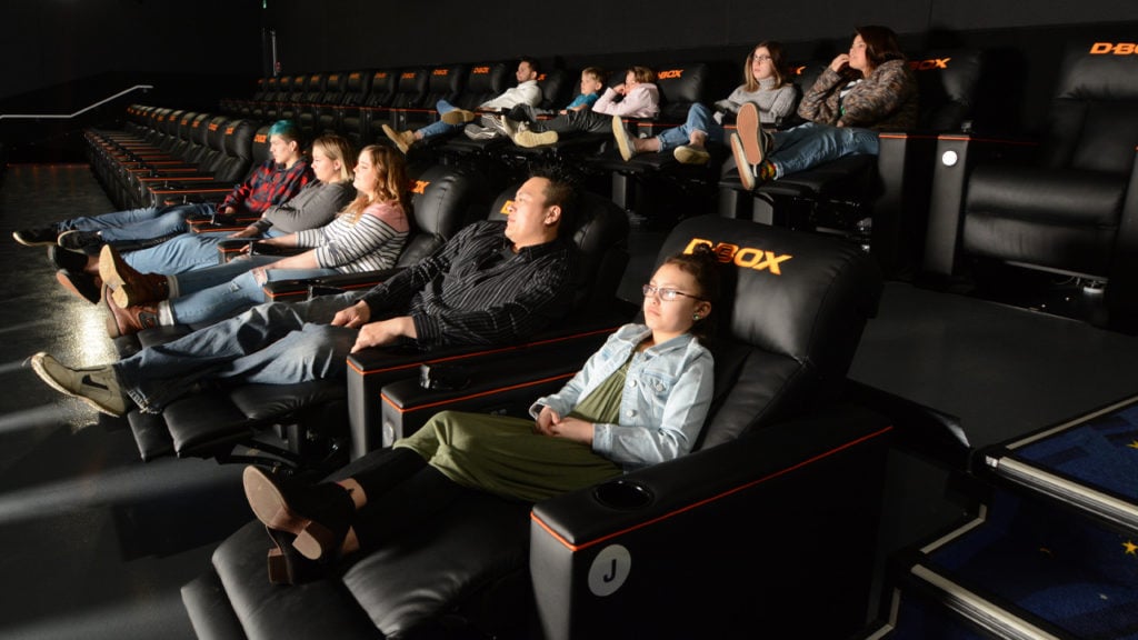 Une petite audience écoute un film dans des sièges de luxe D-BOX