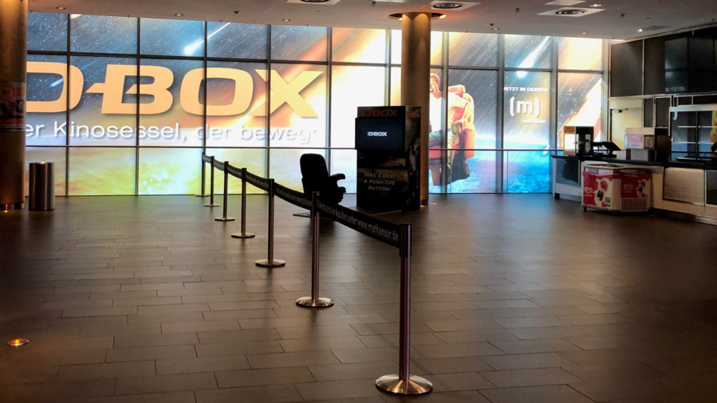 A movie theater lobby with a D-BOX promotion